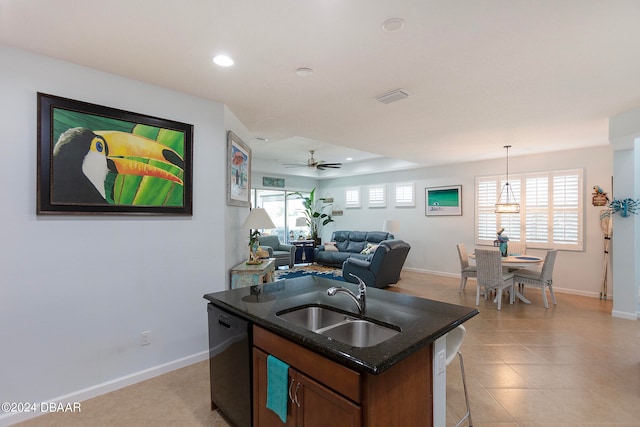 kitchen featuring dishwasher, sink, pendant lighting, a kitchen island with sink, and ceiling fan with notable chandelier