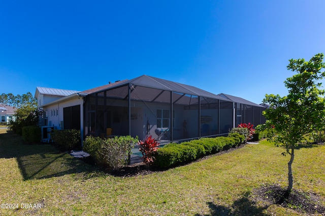 back of house featuring a yard and a lanai