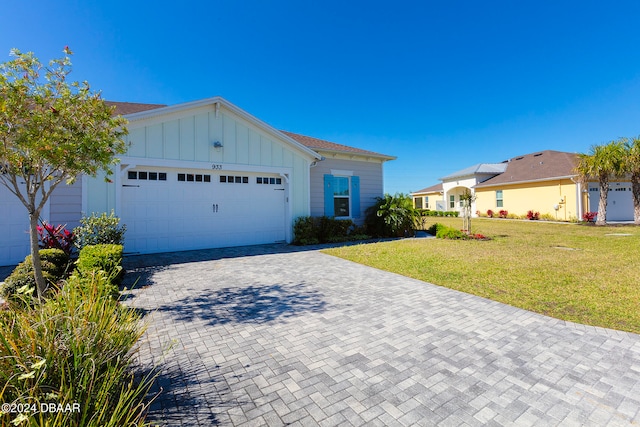 ranch-style house featuring a garage and a front lawn