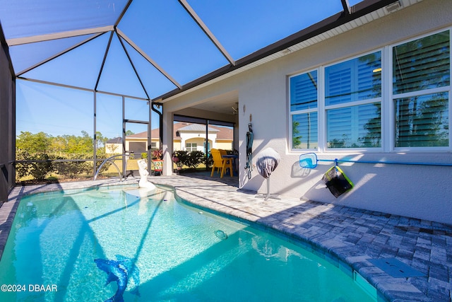 view of swimming pool with glass enclosure and a patio