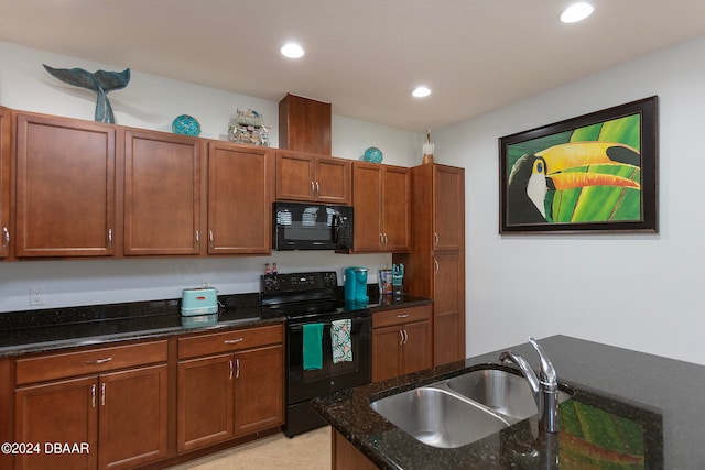 kitchen with black appliances, dark stone countertops, light tile patterned floors, and sink