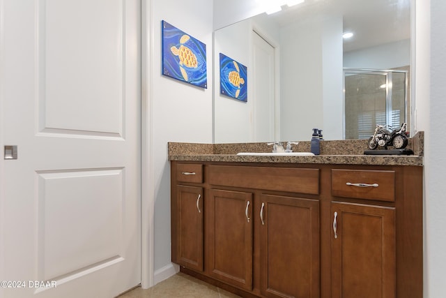 bathroom with tile patterned flooring, vanity, and a shower with door