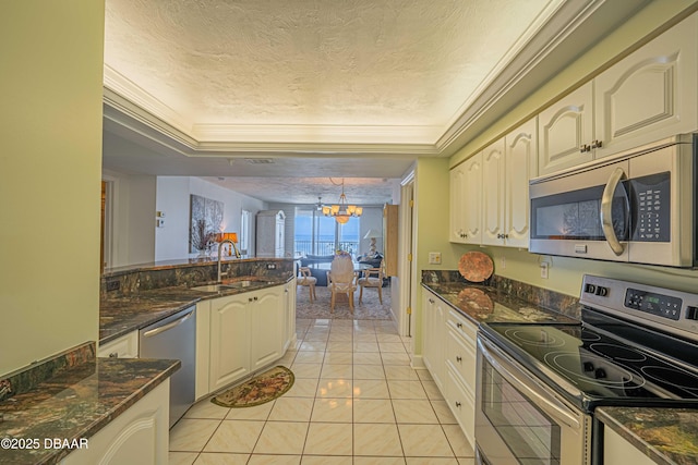 kitchen featuring appliances with stainless steel finishes, a chandelier, sink, and dark stone counters