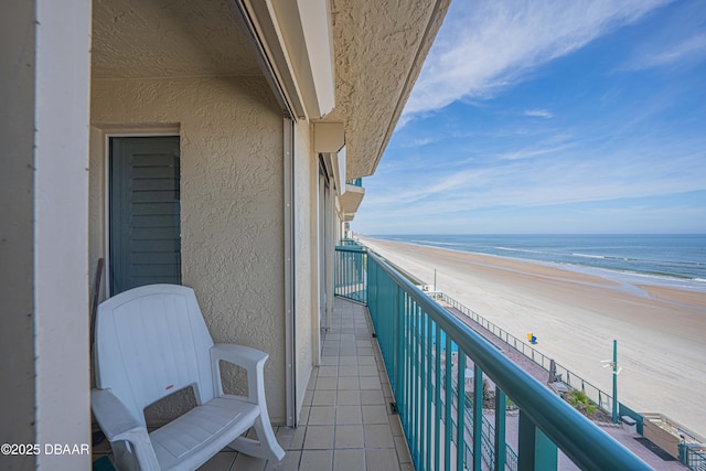 balcony featuring a water view and a view of the beach