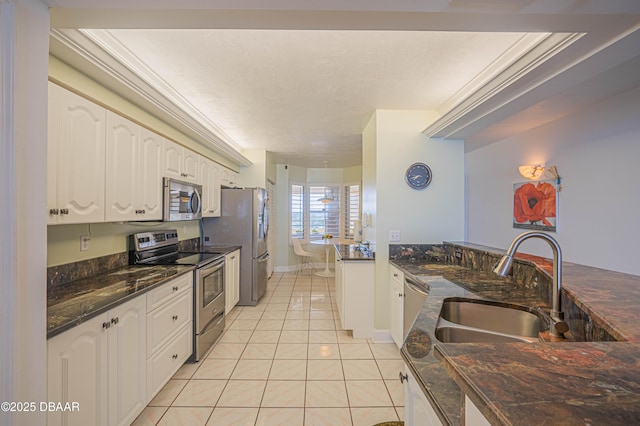 kitchen with light tile patterned flooring, white cabinetry, a textured ceiling, appliances with stainless steel finishes, and dark stone counters