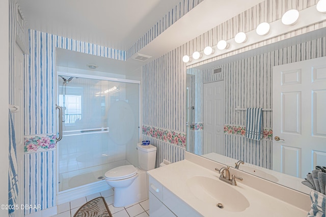 bathroom with tile patterned flooring, vanity, a shower with shower door, and toilet