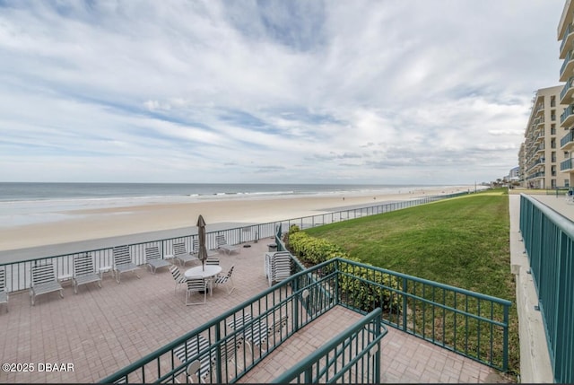 balcony featuring a water view, a beach view, and a patio