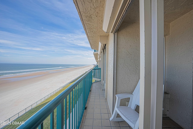 balcony with a water view and a beach view