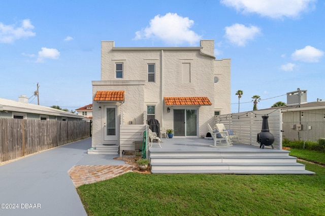 back of house with a lawn and a patio area