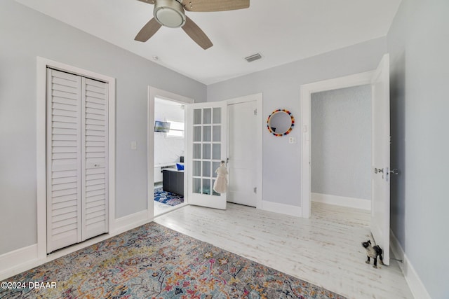 unfurnished bedroom with french doors, light wood-type flooring, a closet, and ceiling fan