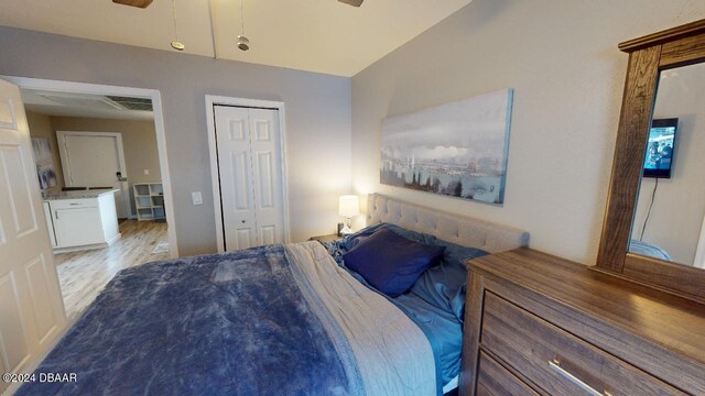 bedroom with ceiling fan, lofted ceiling, light wood-type flooring, and a closet