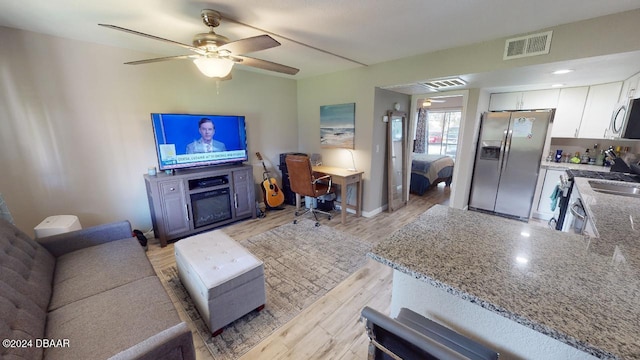 living room with light wood-type flooring and ceiling fan