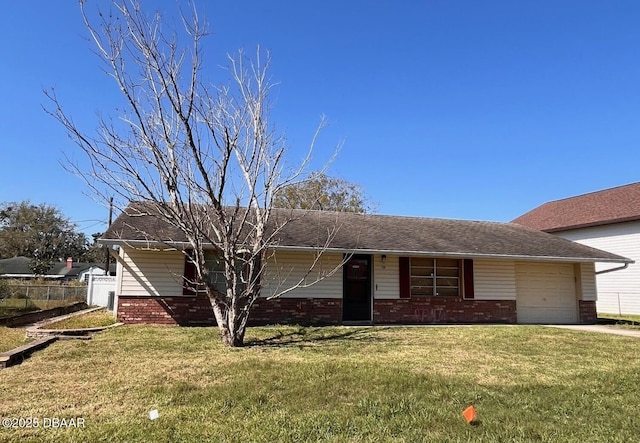view of front facade with a garage, brick siding, a front lawn, and fence