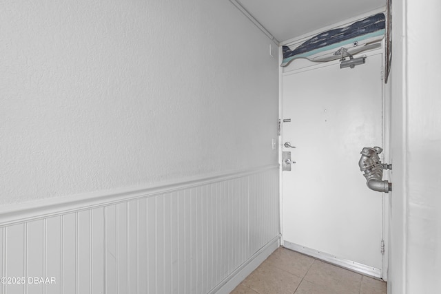 935 S Atlantic Ave Unit 505, Daytona Beach, FL 32118 - hallway featuring light tile patterned flooring and wainscoting