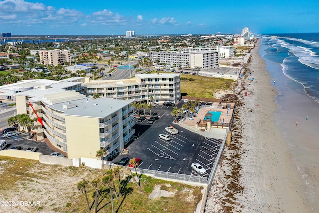 birds eye view of property with a water view and a beach view