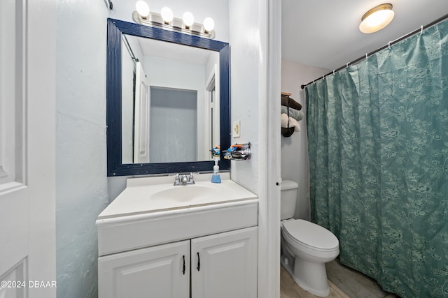 bathroom featuring wood-type flooring, vanity, and toilet