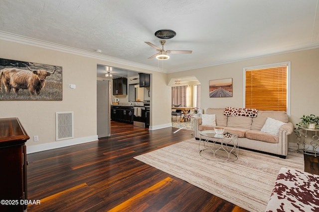 living room featuring a textured ceiling, ceiling fan, dark hardwood / wood-style flooring, and crown molding