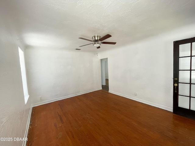 unfurnished room with ceiling fan, wood finished floors, baseboards, and a textured ceiling