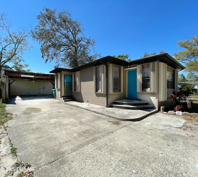 view of front of home with brick siding, concrete driveway, and entry steps