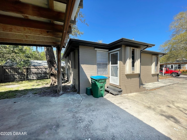 view of property exterior featuring a patio area, entry steps, and fence