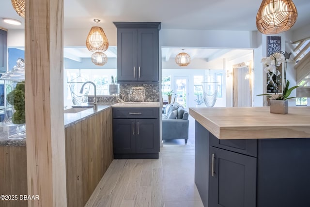 1076 Shockney Dr, Ormond Beach, FL 32174 - kitchen with beam ceiling, hanging light fixtures, a sink, tasteful backsplash, and light stone countertops