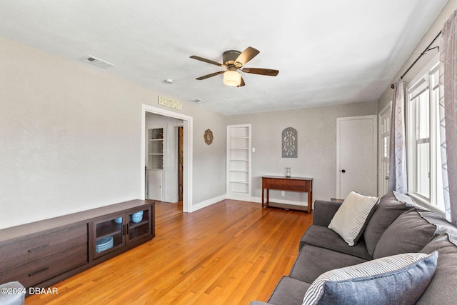 living room featuring a wealth of natural light, ceiling fan, and hardwood / wood-style flooring