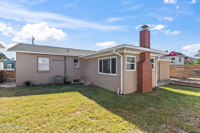 back of house featuring a lawn and central AC unit