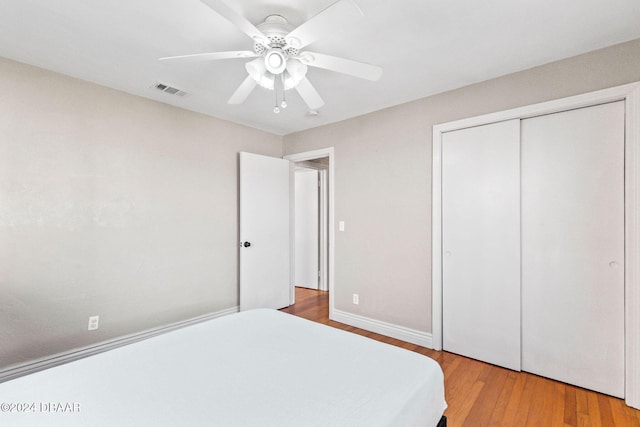 bedroom featuring ceiling fan, a closet, and light hardwood / wood-style flooring