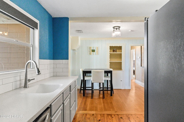 kitchen with gray cabinets, light hardwood / wood-style flooring, and sink