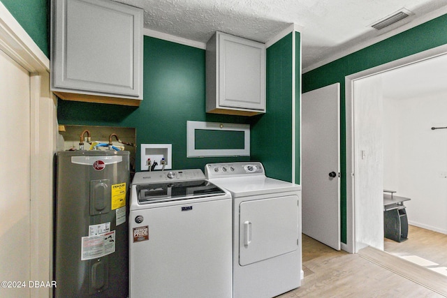 laundry room featuring cabinets, light wood-type flooring, electric water heater, a textured ceiling, and separate washer and dryer