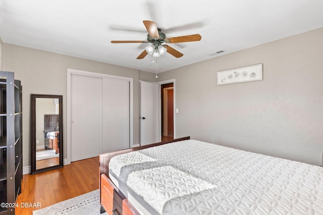 bedroom with hardwood / wood-style flooring, ceiling fan, and a closet