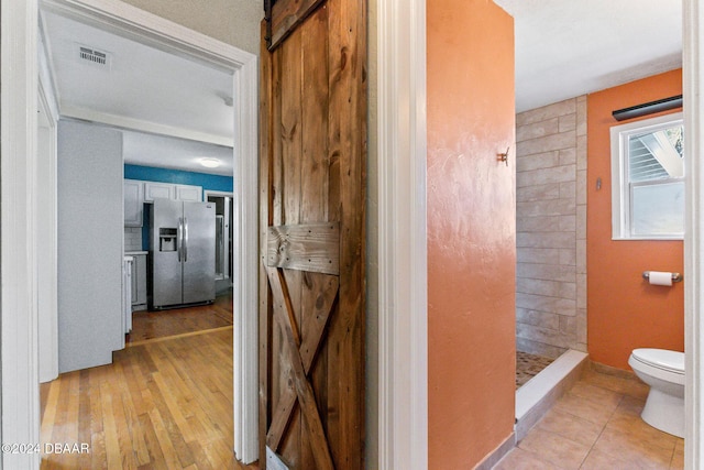 bathroom featuring hardwood / wood-style floors, toilet, and walk in shower