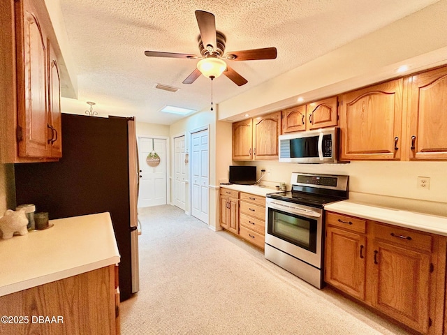 146 Deer Lake Cir, Ormond Beach, FL 32174 - kitchen featuring stainless steel appliances, a textured ceiling, a ceiling fan, light countertops, and light carpet