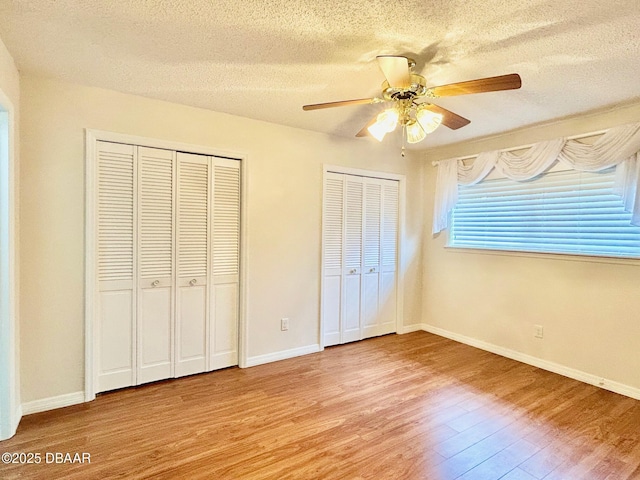 146 Deer Lake Cir, Ormond Beach, FL 32174 - unfurnished bedroom featuring light wood-style flooring, two closets, a textured ceiling, and ceiling fan