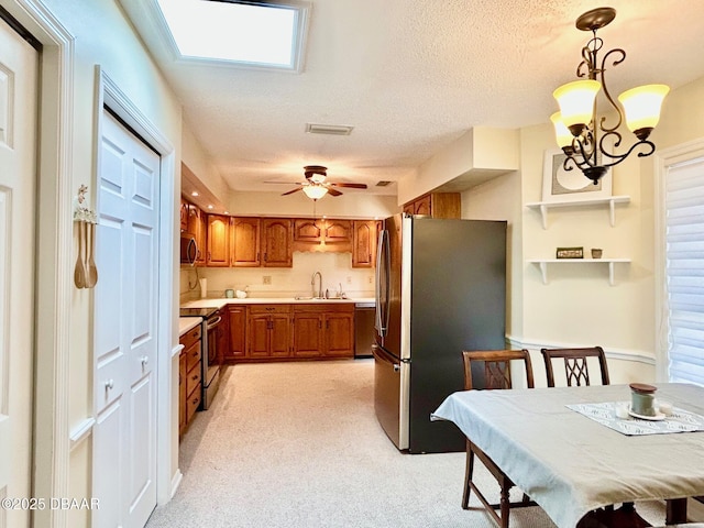 146 Deer Lake Cir, Ormond Beach, FL 32174 - kitchen featuring appliances with stainless steel finishes, brown cabinets, light countertops, light colored carpet, and ceiling fan