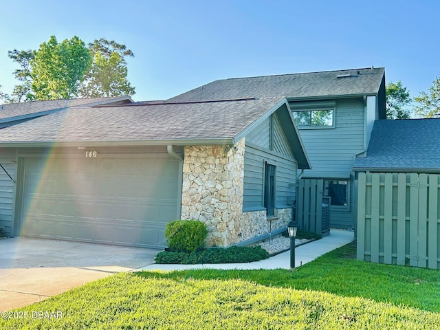 146 Deer Lake Cir, Ormond Beach, FL 32174 - view of front facade featuring roof with shingles, stone siding, an attached garage, concrete driveway, and a front lawn