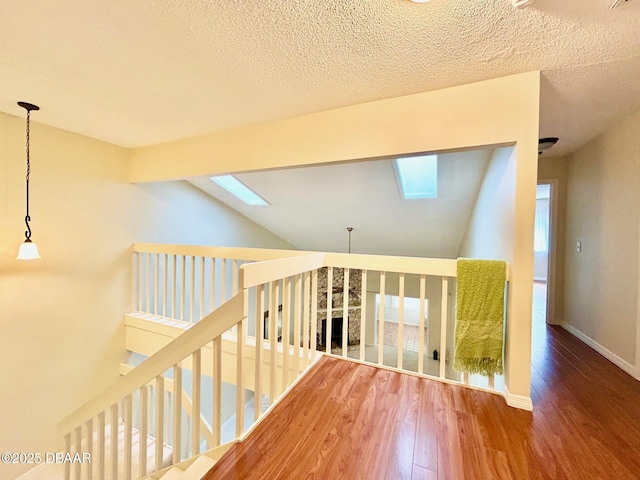 146 Deer Lake Cir, Ormond Beach, FL 32174 - hallway with a skylight, wood finished floors, vaulted ceiling, healthy amount of natural light, and an upstairs landing