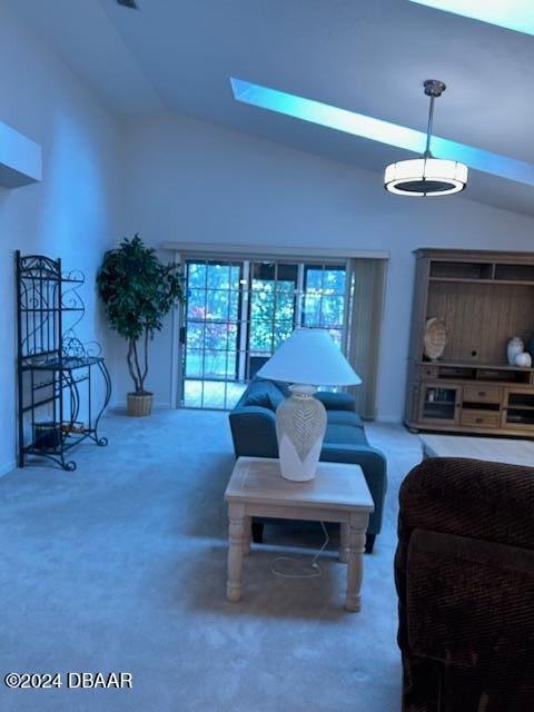 carpeted living room with vaulted ceiling with skylight