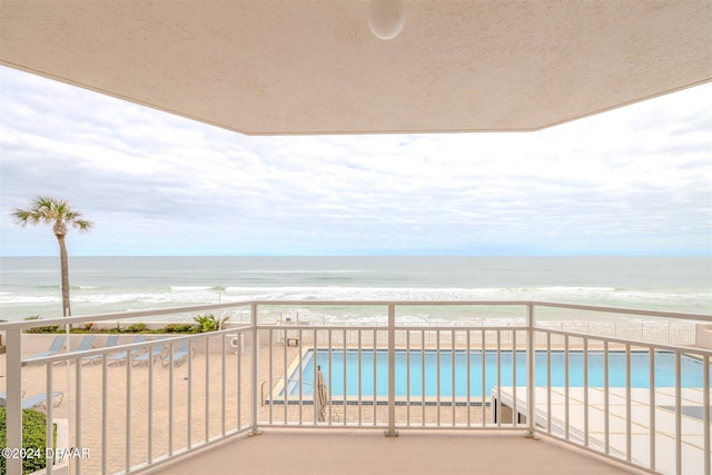 balcony with a water view and a beach view