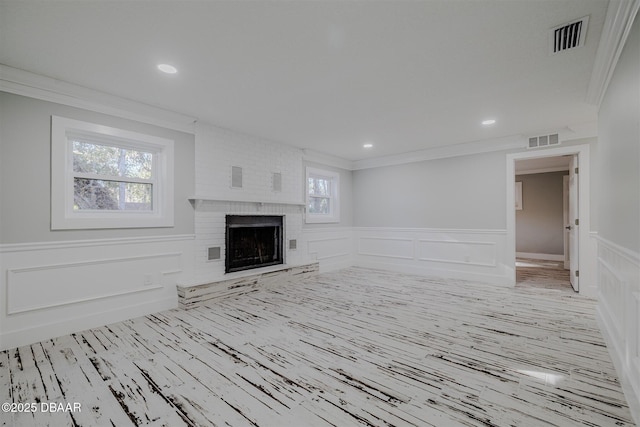 unfurnished living room featuring crown molding and a fireplace