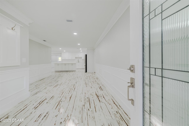 interior space with light hardwood / wood-style floors and ornamental molding