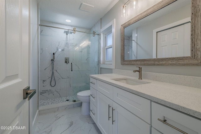 bathroom featuring a shower with door, toilet, and vanity