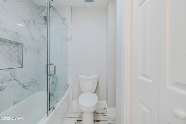 bathroom with toilet and enclosed tub / shower combo