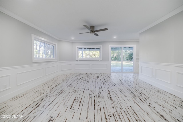 spare room featuring light hardwood / wood-style flooring, ceiling fan, and ornamental molding