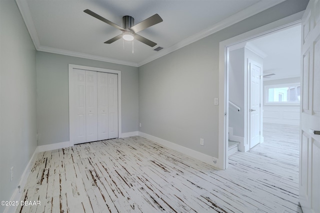 unfurnished bedroom featuring a closet, ceiling fan, ensuite bathroom, light hardwood / wood-style flooring, and crown molding