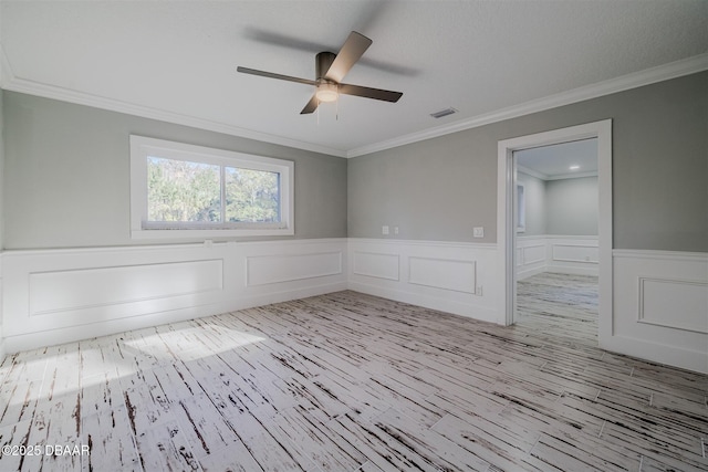 spare room featuring light hardwood / wood-style floors, ceiling fan, and ornamental molding