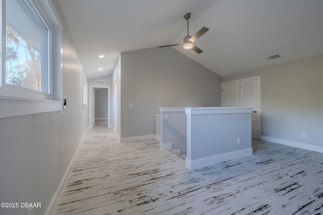 hall with light wood-type flooring and lofted ceiling