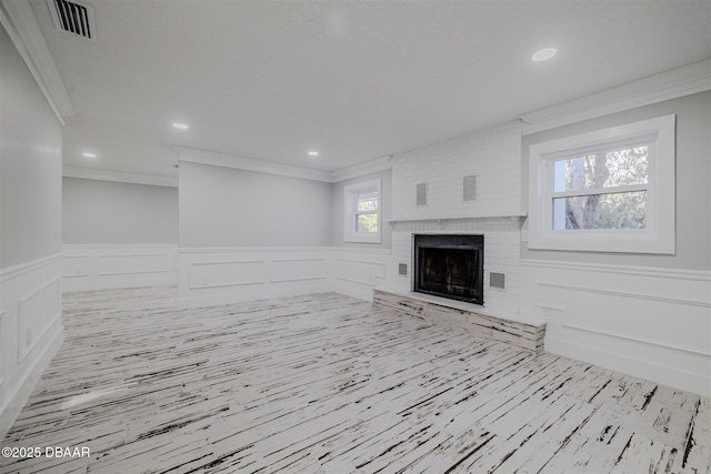 unfurnished living room with ornamental molding and a fireplace