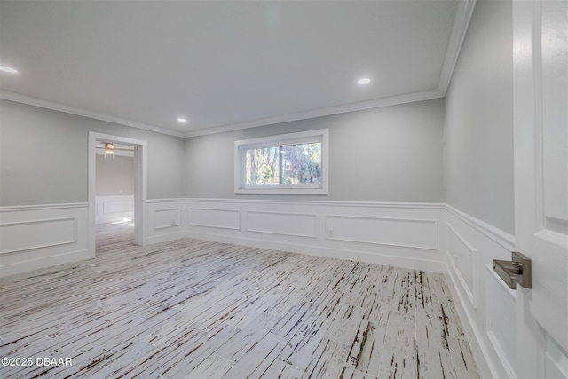 spare room with ornamental molding and light wood-type flooring