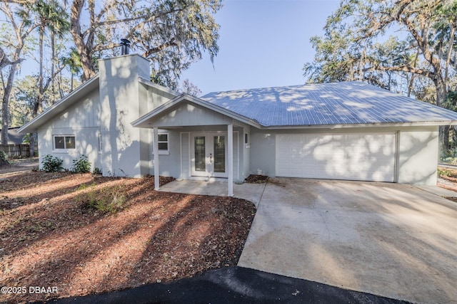 single story home featuring a garage and french doors